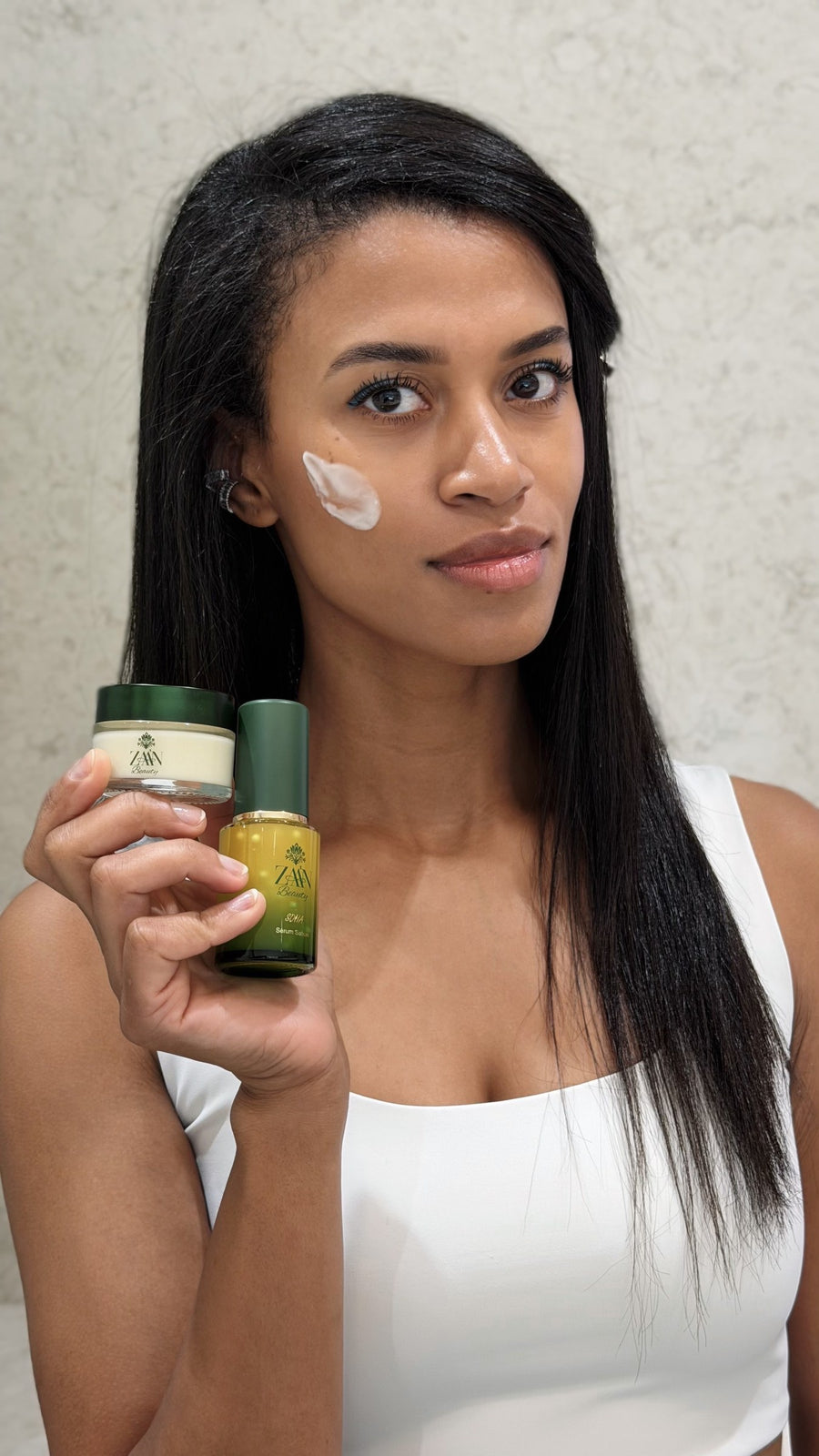 Virginia Dennis applying SHIVA Firming Crème, holding SOHA Wrinkle Smoothing Serum — ZAA'N Beauty