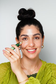 Woman applying ZIBA Firming Eye Serum under the eye